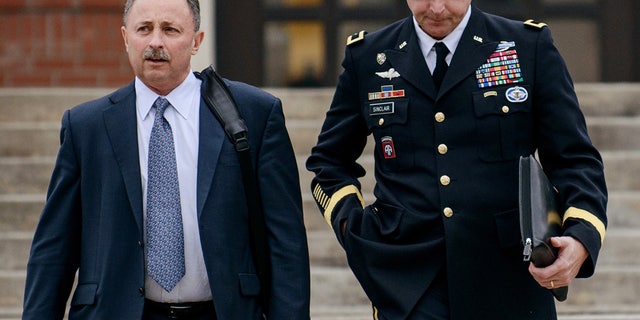 FILE - In this March 4, 2014, file photo, Brig. Gen. Jeffrey Sinclair, right, leaves the courthouse with his lawyers Richard Scheff, left, and Ellen C. Brotman, not pictured, following a day of motions at Fort Bragg, N.C. A military judge declined Monday, March 10, 2014, to dismiss sexual assault charges against Sinclair after reviewing what he said was evidence that political considerations influenced the military's handling of the case. (AP Photo/The Fayetteville Observer, James Robinson, File)