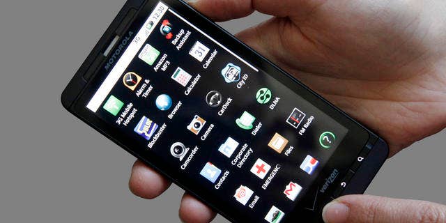 FILE - In this June 30, 2010 file photo, an Associated Press reporter holds the Droid X, the latest addition to Motorola Inc's smart phone line, during a product review in San Francisco. For decades, Motorola's products told the story of the march of electronics into the hands of consumers: car radios in the 1930s, TVs in the 1940s and cell phones in the 1980s. (AP Photo/Jeff Chiu, file)