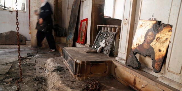 A woman walks inside a damaged church in Maaloula. The Christian town was attacked last spring by extremist forces.
