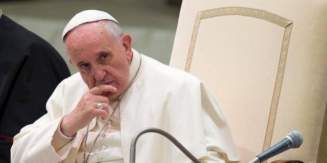 DOSSIER - Dans cette photo d'archive du 4 décembre 2014, le pape François écoute un discours lors d'une audience spéciale qu'il a tenue pour les membres des volontaires catholiques italiens FOCSIV, au Vatican. 