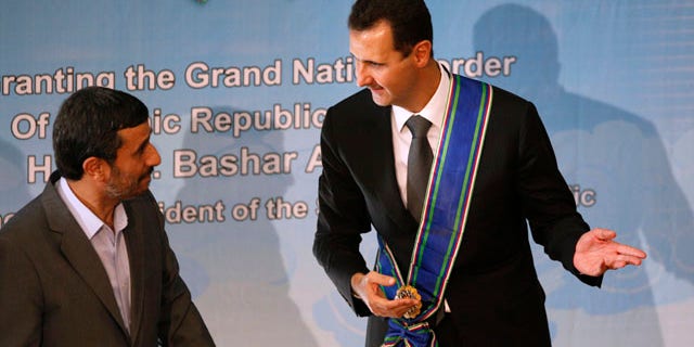 Oct. 2: Syrian President Bashar Assad, right, gestures, after he is awarded with Iran's highest national medal by his Iranian counterpart Mahmoud Ahmadinejad, in Tehran, Iran. Assad has overlooked the White House's efforts to improve relations in favor of alliances with Iran and militant groups such as Hezbollah and the Palestinian Hamas.