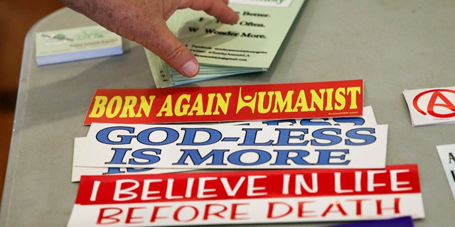 Nov. 10, 2013: An attendee grabs a brochure at the Sunday Assembly, a godless congregation founded by British comedians Sanderson Jones and Pippa Evans.