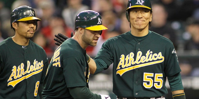 April 23, 2011: Oakland Athletics' Kevin Kouzmanoff, center, is greeted by Hideki Matsui, right, after Matsui and Kurt Suzuki, left, scored when Kouzmanoff hit a three-run home run against the Seattle Mariners in the sixth inning of a baseball game.