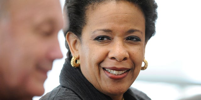 U.S. Attorney General Loretta Lynch listens to East Haven Police Chief Brent Larrabee, left, speak during a community policing tour, Tuesday, July 21, 2015, in East Haven, Conn. Lynch is in Connecticut to highlight improvements in relations between police and Latinos since four officers were arrested in 2012 on abuse charges. (AP Photo/Jessica Hill)