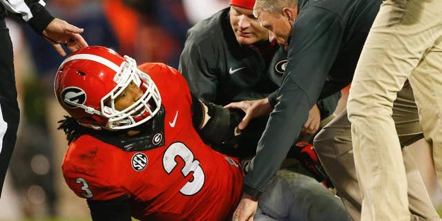 Members of the Georgia medical staff tend to injured running back Todd Gurley in the second half of an NCAA college football game against Auburn Saturday, Nov. 15, 2014, in Athens, Ga. Georgia won 34-7. (AP Photo/John Bazemore)