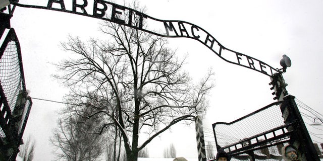 In a Jan. 26, 2005 file photo, visitors walk under the notorious "Arbeit Macht Frei" sign at the entrance gate of the Auschwitz Nazi concentration camp in Oswiecim, southern Poland.