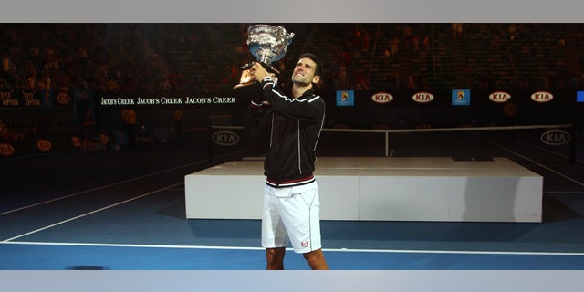 Novak Djokovic of Serbia holds the trophy aloft during the awarding ceremony after defeating Rafael Nadal of Spain in the men's singles final at the Australian Open tennis championship, in Melbourne, Australia, early Monday, Jan. 30, 2012. (AP Photo/Rick Rycroft)