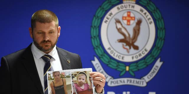 Police Detective Inspector Jason Dickinson holds up a photo of Karlie Jade Pearce-Stevenson and her daughter Khandalyce Kiara Pearce, during a press conference in Sydney, Wednesday, Oct. 21, 2015. A child whose decomposed body was found in a suitcase in southern Australia earlier this year is the daughter of a woman whose skeletal remains were found in 2010 in a forest 1,200 kilometers (750 miles) away, police said. (Dean Lewins/AAP Image via AP) NO ARCHIVING, AUSTRALIA OUT, NEW ZEALAND OUT, PAPUA NEW GUINEA OUT, SOUTH PACIFIC OUT