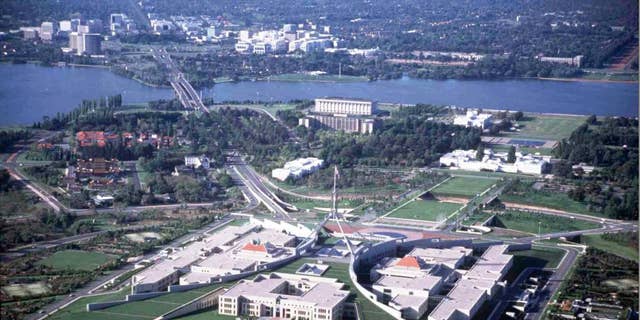 FILE - This undated aerial photo shows Parliament House in Canberra, Australia, and the downtown area at the top. Australia's Parliament House on Monday, Oct. 20, 2014 lifted a short-lived ban on facial coverings including burqas and niqabs after the prime minister intervened. (AP Photo/Canberra Tourism)