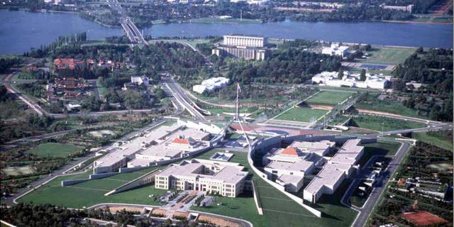 FILE - This undated aerial photo shows Parliament House in Canberra, Australia, and the downtown area at the top. Australia's Parliament House on Monday, Oct. 20, 2014 lifted a short-lived ban on facial coverings including burqas and niqabs after the prime minister intervened. (AP Photo/Canberra Tourism)