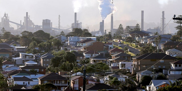 FILE - In this July 2, 2014 file photo, smoke billows out of a chimney stack of steel works factories in Port Kembla, south of Sydney. (AP Photo/Rob Griffith, File)