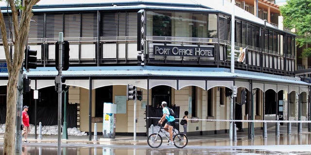 Jan. 13: A cyclist pedals past the Port Office Hotel in the city center of Brisbane, Australia.