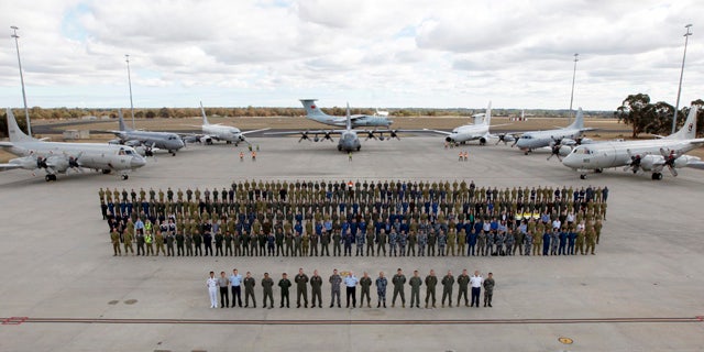 April 29, 2014: In this photo provided by the Australia Defence Force, multinational air-crew and aircraft involved in operation 'Southern Indian Ocean' are assembled for a photo at RAAF Base Pearce, in Perth, Western Australia. Seven nations, including Australia, New Zealand, the U.S., South Korea, Malaysia, China and Japan, have flew daily search mission out to the southern Indian Ocean in the massive multinational hunt for the missing Malaysia Airlines Flight 370. (AP Photo/Australian Defence Force, Cpl. Nicci Freeman)