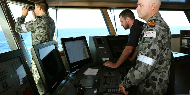 In this April 5, 2014, photo provided by the Australian Defense Force, Commander James Lybrand, right, watches from the bridge with Captain Nick Woods, Master of the ship, left, as they tow a pinger locator behind the Royal Australian Navy ship Ocean Shield in the southern Indian Ocean. Ocean Shield, which is carrying high-tech sound detectors from the U.S. Navy, is investigating a sound it picked up. (AP Photo/Australian Defense Force, Bradley Darvill) EDITORIAL USE ONLY