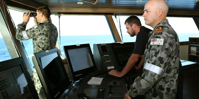In this April 5, 2014, photo provided by the Australian Defense Force, Commander James Lybrand, right, watches from the bridge with Captain Nick Woods, Master of the ship, left, as they tow a pinger locator behind the Royal Australian Navy ship Ocean Shield in the southern Indian Ocean. Ocean Shield, which is carrying high-tech sound detectors from the U.S. Navy, is investigating a sound it picked up. (AP Photo/Australian Defense Force, Bradley Darvill) EDITORIAL USE ONLY