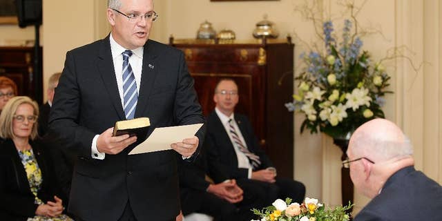 FILE - In this Monday, Sept. 21, 2015, file photo, Australia's Treasurer Scott Morrison, left, is sworn in by Governor-General Peter Cosgrove, right, during the swearing-in ceremony of Prime Minister Malcolm Turnbull's cabinet at Government House in Canberra, Australia. Turnbull received a boost from a respected opinion poll on Tuesday, Sept. 22, 2015, but the fallout lingers from a bitter party battle as the leader he ousted has attacked the credibility of Morrison. A Newspoll published in The Australian newspaper on Tuesday found that Turnbull is Australia's most popular prime minister in more than five years - a period that covered the terms of Julia Gillard, Kevin Rudd and Tony Abbott. (Stefan Postles/Pool Photo via AP, File)