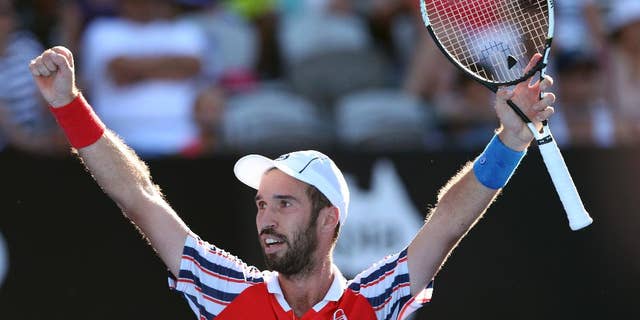 Mikhail Kukushkin of Kazakhstan raises his arms as he celebrates winning his match against Juan Martin del Potro of Argentina at the Sydney International Tennis tournament in Sydney, Australia, Thursday, Jan. 15, 2015. (AP Photo/Rob Griffith)