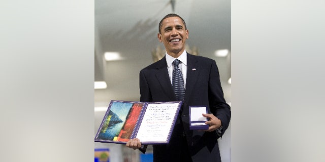 US President and Nobel Peace Prize laureate Barack Obama, holds his medal and diploma at the Nobel Peace Prize ceremony at City Hall in Oslo, Thursday, Dec. 10, 2009. (AP Photo Bjorn Sigurdson/ Scanpix Norway, Pool)