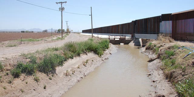 The uncompleted border fence along Fort Hancock, Texas, separating the town from Mexico's harsh terrain.