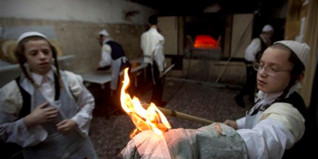 Ultra-Orthodox Jews prepare special matzoh, a traditional handmade Passover unleavened bread, at a bakery in Jerusalem, Wednesday, April 1, 2015. (AP Photo/Sebastian Scheiner)
