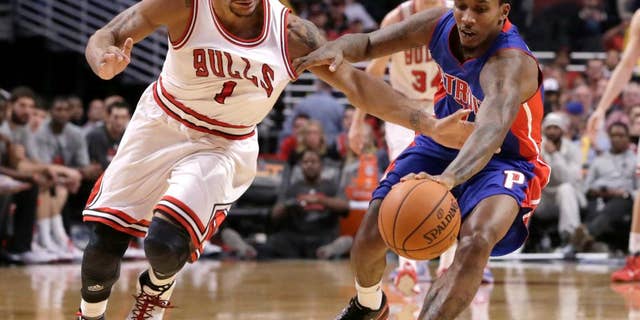 Derrick Rose (1) de los Bulls de Chicago disputa un balón con Brandon Jennings (7) for a loose ball during the second half of an NBA basketball game Monday, Nov. 10, 2014, in Chicago. The Bulls won 102-91. (AP Photo/Charles Rex Arbogast)