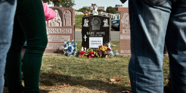 Visitors gather at the grave of Baby Hope, Anjelica Castillo, on Monday, Oct. 14, 2013 in the Bronx borough of New York.