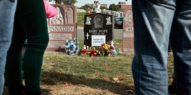 Visitors gather at the grave of Baby Hope, Anjelica Castillo, on Monday, Oct. 14, 2013 in the Bronx borough of New York.