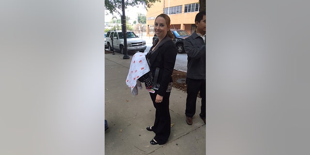 In this Oct 7, 2014 photo released by Stacy Ehrisman-Mickle, Ehrisman-Mickle poses for a photo with her daughter, in Atlanta. Ehrisman-Mickle, an immigration lawyer, brought her 4-week-old baby to court after Immigration Judge J. Dan Pelletier Sr. denied her request to delay a hearing that fell during her maternity leave. During the hearing, her baby began to cry, and Pelletier scolded her for inappropriate behavior. (AP Photo/Stacy Ehrisman-Mickle)