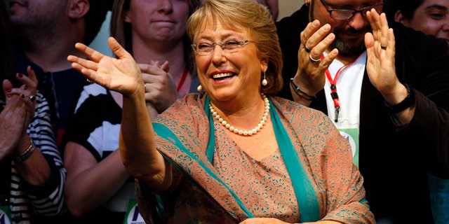 Presidential candidate Michelle Bachelet waves during a victory rally in Santiago, Chile, Sunday, Dec. 15, 2013. With 90 percent of the votes counted, Bachelet had an unbeatable 62 percent to 38 percent for the center-right's Evelyn Matthei, who has conceded defeat. (AP Photo/Luis Hidalgo).
