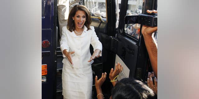 Republican presidential candidate Rep. Michele Bachmann, R-Minn., reacts to a group of supporters as emerges from her campaign bus after winning the Republican Party's Straw Poll in Ames, Iowa, Saturday, Aug. 13, 2011. (AP Photo/Charles Dharapak)