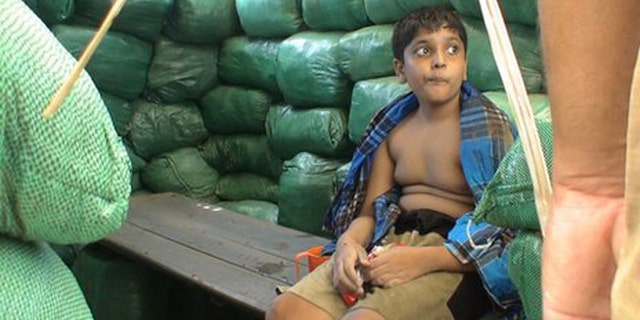 Balachandran Prabhakaran, shown eating chocolate while sitting on a bench.