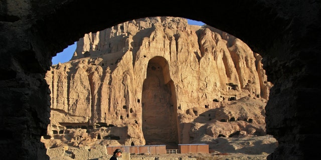 An Afghan man rides his motorcycle past the remains of the Giant Buddha destroyed by the Taliban in March 2001 in central Bamiyan province 162 miles northwest of Kabul March 30, 2005.