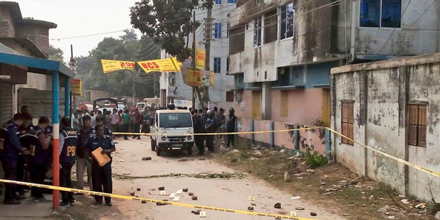Nov. 18, 2015: Members of Bangladesh's Police Bureau of Investigation stand by the site where an Italian priest was attacked.