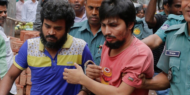 Suspected members of the banned Islamic militant outfit Ansarullah Bangla Team, Sadek Ali, second right, and Aminul Mollick, front left, are escorted by policemen along with another suspect from a court in Dhaka, Bangladesh.