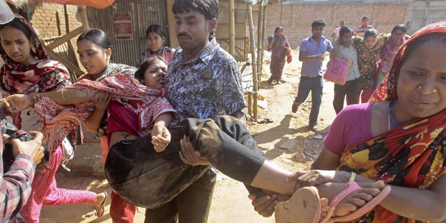 November 12, 2013: Bangladeshi garment workers assist their colleagues injured during a clash with police in Ashulia, outskirts of Dhaka, Bangladesh. Thousands of garment workers demanding higher pay clashed with police for a second day Tuesday, leaving dozens of people injured and at least 200 factories closed, police said. (AP Photo/A.M. Ahad)