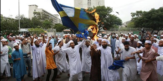 May 28, 2010: Bangladeshi Muslim protesters burn a Swedish flag during a protest against Facebook. Reportedly, Swedish artist Lars Vilks has angered many Muslims by caricatures of the Prophet Muhammad.