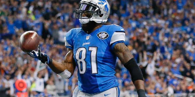 Detroit Lions wide receiver Calvin Johnson tosses the ball after his 25-yard reception for a touchdown during the first half of an NFL football game against the Chicago Bears in Detroit, Thursday, Nov. 27, 2014. (AP Photo/Rick Osentoski)