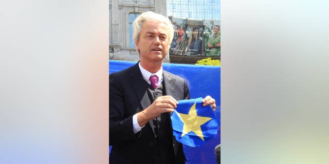 Dutch populist and euro-sceptic Geert Wilders shows a yellow star he cut out of the EU flag in front of the European Parliament in Brussels, Tuesday, May 20, 2014. Wilders is campaigning on a platform forbidding any further transfer of power to Europe, scrapping the Euro and control of immigration policy. (AP Photo/Yves Logghe)
