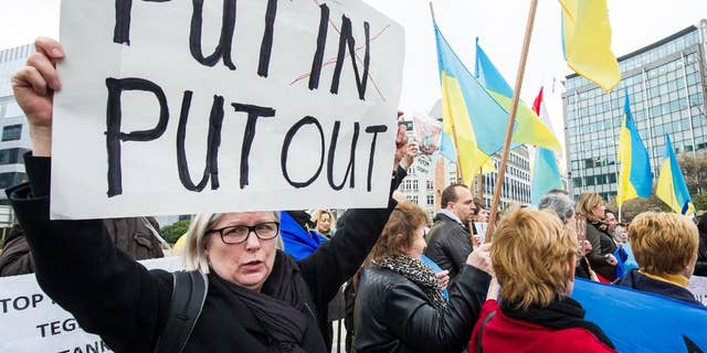 Pro-Ukrainian activists demonstrate during an EU foreign ministers meeting outside the EU Council in Brussels, Monday, March 17, 2014. British Foreign Secretary William Hague says he is confident that the European Union will ratchet up pressure on Russia over its role in the breakaway of Ukraine's Crimea region by imposing sanctions on people linked to the secession of the peninsula. The 28-nation EU condemned the Crimea referendum which overwhelmingly backed a return to Russia, and the EU foreign ministers were assessing on Monday who to target for asset freezes and travel bans. (AP Photo/Geert Vanden Wijngaert)