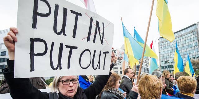 Pro-Ukrainian activists demonstrate during an EU foreign ministers meeting outside the EU Council in Brussels, Monday, March 17, 2014. British Foreign Secretary William Hague says he is confident that the European Union will ratchet up pressure on Russia over its role in the breakaway of Ukraine's Crimea region by imposing sanctions on people linked to the secession of the peninsula. The 28-nation EU condemned the Crimea referendum which overwhelmingly backed a return to Russia, and the EU foreign ministers were assessing on Monday who to target for asset freezes and travel bans. (AP Photo/Geert Vanden Wijngaert)