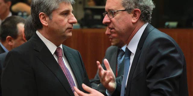 Austrian Finance Minister Michael Spindelegger, left, talks with his Luxembourg's counterpart Pierre Gramegna at the start of an EU finance ministers meeting at the European Council building in Brussels, Tuesday, March 11, 2014. The Council prepares the presidency's mandate to finalize negotiations with the European Parliament on the proposal for a single resolution mechanism for banks. (AP Photo/Yves Logghe)