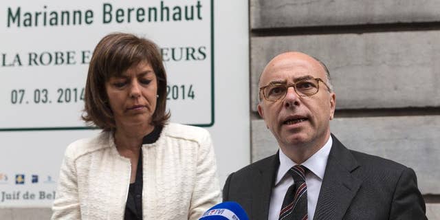 FILE - In this June 4, 2014 file photo, French Interior Minister Bernard Cazeneuve, right, and Belgium's Interior Minister Joelle Milquet speak with the press after laying a wreath at the Jewish Museum in Brussels on Wednesday, June 4, 2014. Recruiters for Islamic extremist groups are increasingly targeting French women and girls, with nearly 100 either in Syria or on their way and 175 being monitored at home, security officials say. France’s Interior Ministry on Tuesday Sept.16, 2014 posted a video showing anguished family members of young people who left to fight alongside extremists, including a young man whose 15-year-old sister set out for what she thought was a humanitarian aid mission. She has not returned.  (AP Photo/Thierry Monasse, File)