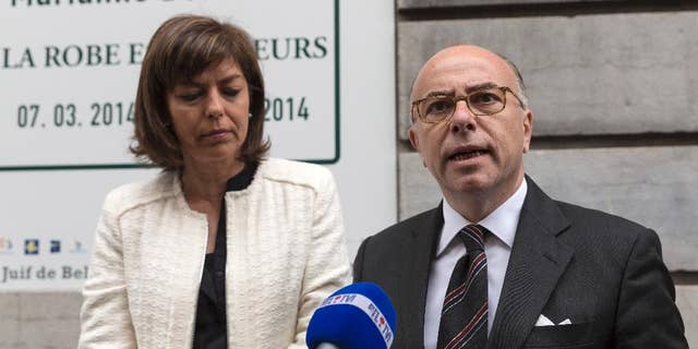 FILE - In this June 4, 2014 file photo, French Interior Minister Bernard Cazeneuve, right, and Belgium's Interior Minister Joelle Milquet speak with the press after laying a wreath at the Jewish Museum in Brussels on Wednesday, June 4, 2014. Recruiters for Islamic extremist groups are increasingly targeting French women and girls, with nearly 100 either in Syria or on their way and 175 being monitored at home, security officials say. France’s Interior Ministry on Tuesday Sept.16, 2014 posted a video showing anguished family members of young people who left to fight alongside extremists, including a young man whose 15-year-old sister set out for what she thought was a humanitarian aid mission. She has not returned. (AP Photo/Thierry Monasse, File)