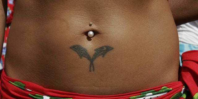 PARIS - JULY 20: Tatoo detail and pierced navel is observed on the body of an Ocean Pacific Islander performer during the opening of 'Paris Plage' 2006 on July 20, 2006 in Paris, France. The Paris Plage, an artificial beach along the banks of Seine River, began in 2002 and has since been replicated in Berlin, Rome and other European cities. (Photo by Bernard Bisson/ Getty Images)