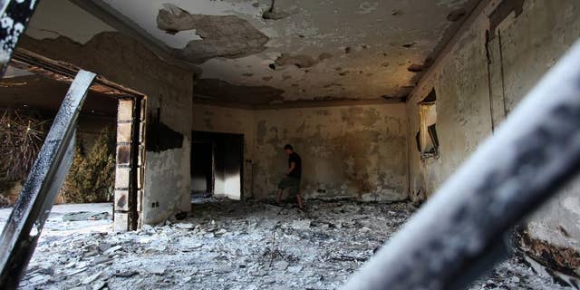 FILE - This Sept. 13, 2012 file photo shows a Libyan man walking in the rubble of the damaged U.S. consulate, after an attack that killed four Americans, including Ambassador Chris Stevens on the night of Tuesday, Sept. 11, 2012, in Benghazi, Libya. To congressional Republicans, "Benghazi" is shorthand for incompetence and cover-up. Democrats hear it as the hollow sound of pointless investigations. It is, in fact, a Mediterranean port city in Libya that was the site of an attack on an American diplomatic compound on the 11th anniversary of 9/11 that killed U.S. Ambassador Chris Stevens and three other Americans. That's nearly all that U.S. politicians can agree on about Benghazi. (AP Photo/Mohammad Hannon, File)