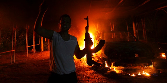 FILE 2012: A protester reacts as the U.S. Consulate in Benghazi is seen in flames. Sixty-six percent of voters want Congress to keep investigating the White House’s handling of Benghazi, according to a Fox News poll.