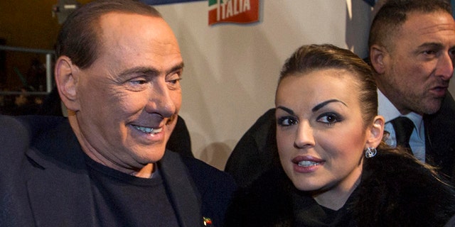Nov. 27, 2013: Silvio Berlusconi, left, is flanked by his girlfriend Francesca Pascale as he leaves after addressing a rally in Rome.