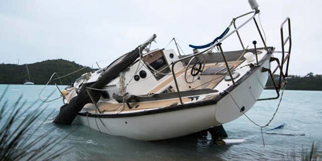 A sailboat lays damaged on the shore of Ferry Reach after breaking free from its mooring after the passing of Hurricane Nicole in St. Georges, Bermuda, Thursday, Oct. 13, 2016. Nicole pummeled the resort island as a Category 3 storm with winds that snapped trees and peeled off roofs before it spun away into open water as a Category 1 storm. (AP Photo/Mark Tatem)