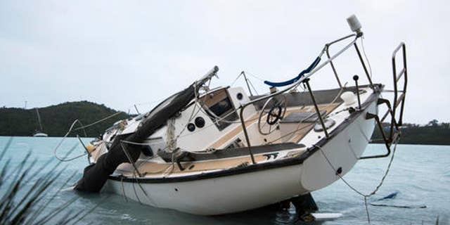 A sailboat lays damaged on the shore of Ferry Reach after breaking free from its mooring after the passing of Hurricane Nicole in St. Georges, Bermuda, Thursday, Oct. 13, 2016. Nicole pummeled the resort island as a Category 3 storm with winds that snapped trees and peeled off roofs before it spun away into open water as a Category 1 storm. (AP Photo/Mark Tatem)