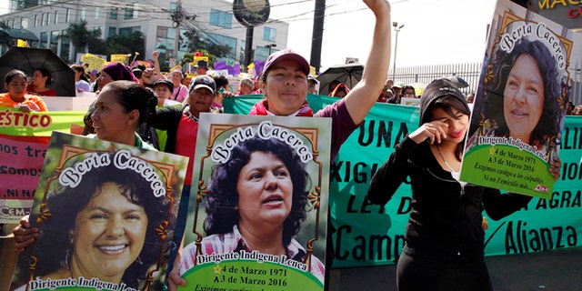 Women carry images of slain environmental activist Berta Caceres during the commemoration of International Women's Day in Tegucigalpa, Honduras, Tuesday, March 8, 2016. Caceres, a Lenca Indian activist who won the 2015 Goldman Environmental Prize for her role in fighting a dam project was killed by unknown assailants on March 3, 2016. She had previously complained of receiving death threats from police, soldiers and local landowners because of her work. (AP Photo/Fernando Antonio)